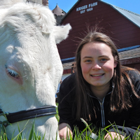 MSU agribusiness management student Lynn Olthof with cow on a farm.