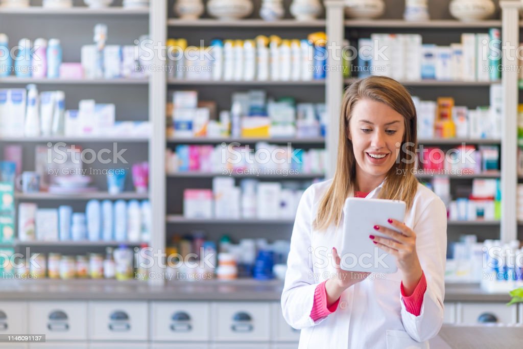 Portrait Of Pharmacist Holding Digital Tablet In Pharmacy Stock Photo -  Download Image Now - iStock